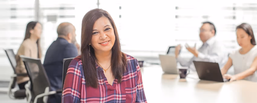 A portrait of a TransLink office employee in a meeting room with people in background