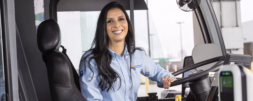 A CMBC bus operator smiling while holding the steering wheel with one hand