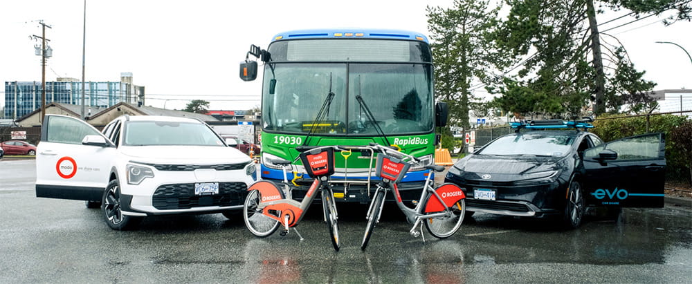 A modo car, RapidBus, Evo car and two Mobi bikes, posed in the rain