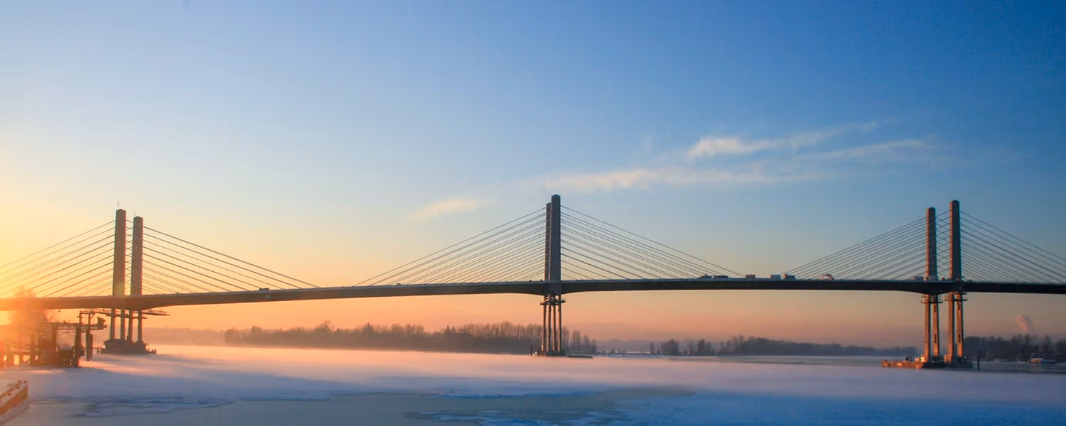 A view of Golden Ears Bridge with the sun rising in the background