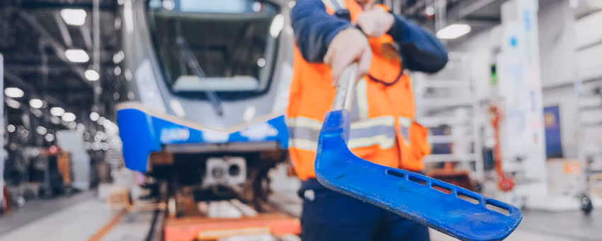 SkyTrain employee holds a plastic hockey stick in front of a SkyTrain