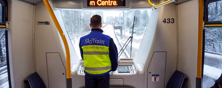 SkyTrain attendant monitors the tracks at the helm of a SkyTrain during snowy weather