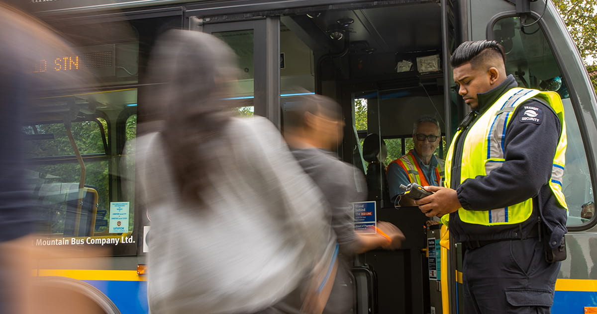 Transit security personnel scanning Compass Cards as customers board a bus