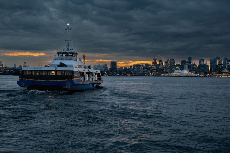 SeaBus leaving Lonsdale Quay at sunset with downtown Vancouver skyline in background