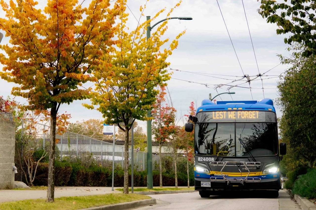 A bus with the words LEST WE FORGET displayed on the sign